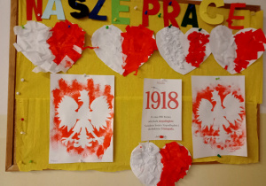 Tablica z pracami uczniów - biało czerwone serca oraz orły.