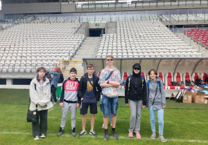 Dziewczęta i chłopcy na murawie stadionu.