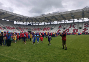 Bardzo duża grupa uczniów w koszulkach organizatorów - cztery kolory.