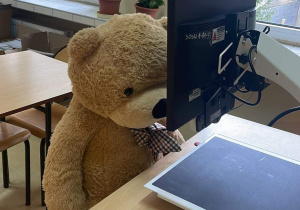 Pluszowy Miś siedzi przed powiększalnikiem