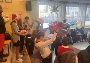 Uczniowie pokazują otrzymane prezenty.