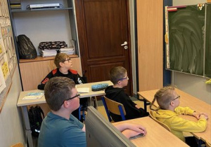 Uczniowie w pracowni słuchają film.