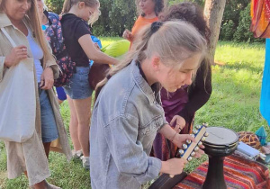 Uczennica próbuje gry na różnych instrumentach.