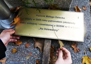 Tabliczka informująca, że patronem pomnika jest młodzież z SOSW nr 6