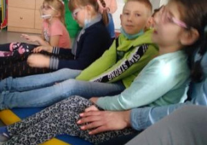 Dzieci siedzące na podłodze i rozpoznające odgłosy lasu.