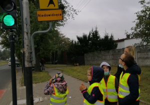 Dzieci przyglądające się znakom pionowym przy ruchliwej ulicy Warszawskiej.