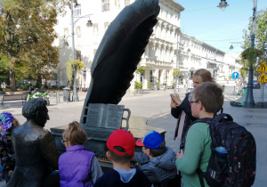 Dzieci stojące przed pomnikiem Artura Rubinsteina.