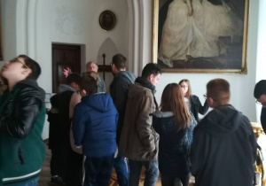 Uczniowie słuchający kustosza w muzeum