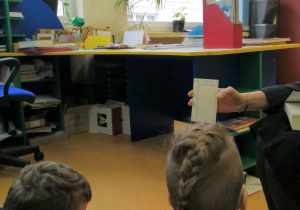 Nauczycielka prezentuje kartę biblioteczną.