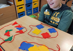 Chłopiec połączył klocki w trzy zbiory: prostokątów, kwadratów i trójkątów.