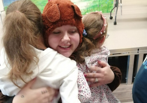 Dziewczynki przytulają aktorkę przebraną za misia.