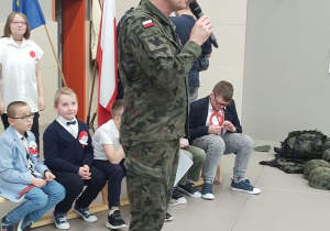 Żołnierz przemawiający do uczniów.