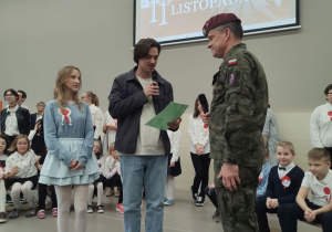 Przedstawiciele samorządu uczniowskiego wręczają podziękowania żołnierzowi.