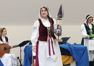 Aktorka prezentuje kaszubski instrument muzyczny "Diabelskie skrzypce ludowe".