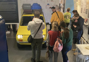 Uczniowie oglądają eksponaty w Muzeum Życia w PRL - Fiat 126 p.