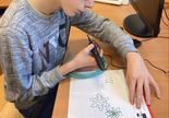 Chłopiec rysuje długopisem 3D po śladzie śnieżynki.