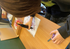 Dziewczynka rysuje gwiazdę długopisem 3D.