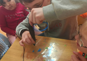 Uczeń wykonuje długopisem 3D model cząsteczki wody.