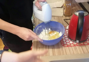 Uczeń miksuje ciasto mikserem