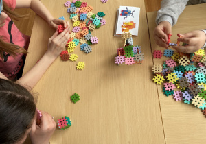 Dzieci budują z klocków figurki według wzorów.