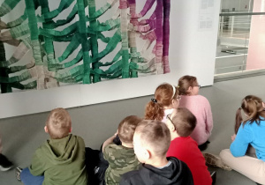 Dzieci obserwują pracę plastyczną w muzeum.