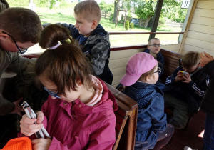 Dzieci w wagonie kolejki wąskotorowej.