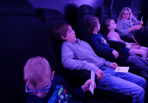 Dzieci w sali planetarium oczekujące na pokaz.