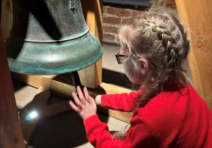 Dziewczynka dotyka dzwon.