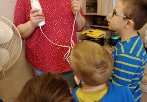 Nauczycielka opowiada chłopcom o bezpiecznym zastosowaniu blendera.