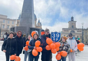 Uczniowie z pomarańczowymi balonami na Placu Wolności.