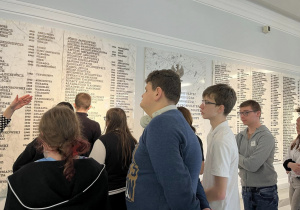 Uczniowie przed tablicą pamiątkową.