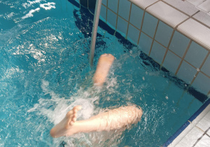 Niewidoma pływaczka dotykana kijem - informacja o końcu toru.