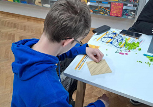 Uczniowie budują z klocków Lego.