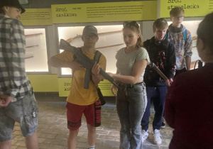 Uczniowie trzymający w rękach eksponaty - broń długolufową.