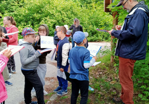 Uczniowie słuchają opowieści przewodnika.