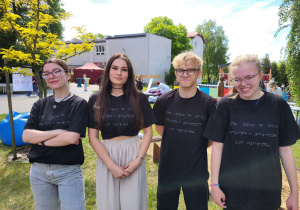 Uczniowie w koszulkach z napisami brajla.