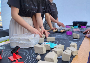 Uczniowie przygotowują glinę do warsztatów ceramicznych.