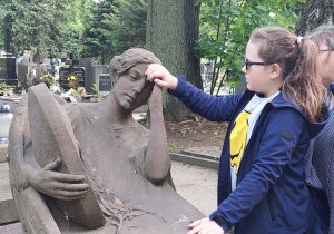 Uczennica dłońmi analizuje rzeźbę.
