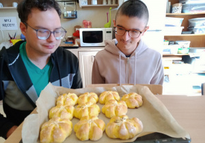 Chłopcy z blachą upieczonych bułeczek dyniowych.