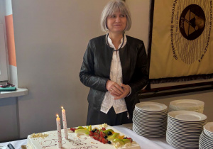 Dyrektor Anna Tomaszewska obok jubileuszowego tortu.