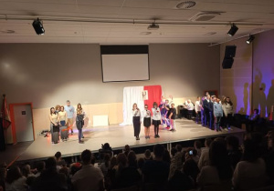 Występujący uczniowie na scenie podczas apelu.