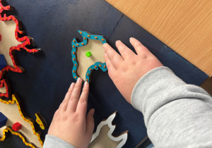 Dłonie uczennicy na mapie.