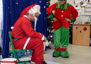 Na scenie aktorzy w strojach skrzata i Mikołaja.