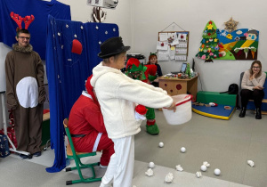 Na scenie nauczycielka w stroju bałwanka rzuca śniegowymi kulkami.