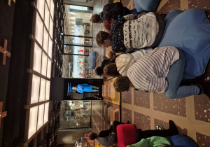 Uczniowie słuchają prelekcji w muzeum.