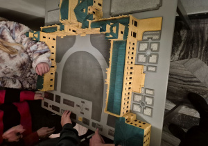 Uczniowie dotykają makiety zamku.