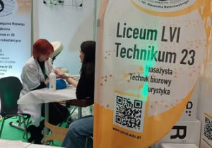 Uczennica masuje klientkę stoiska.