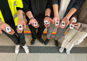 Na dłoniach ułożone z liter słowo: Ireland.