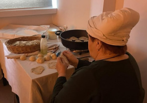 Kobieta wyrabia ciasto na podpłomyki.