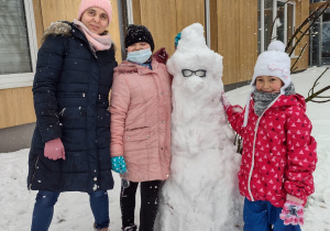 Uczniowie z wychowawczynią obok bałwana